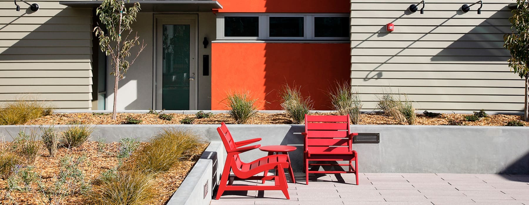 red chairs in front of modern buildings containing nearby landscaping